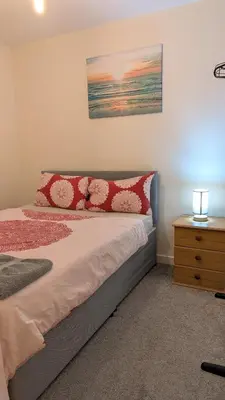 a bedroom with a bed with red and white pillows at NG Property in Glasgow
