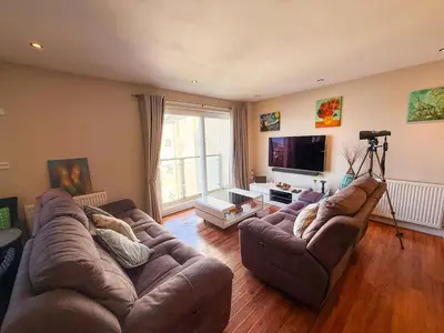 a living room with two couches and a flat screen tv at Marina View Apartment with Balcony & Sea Views in Horse Isle