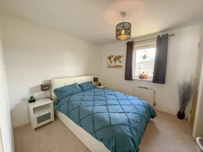 a bedroom with a bed with a blue comforter and a window at Marina View Apartment with Balcony & Sea Views in Horse Isle