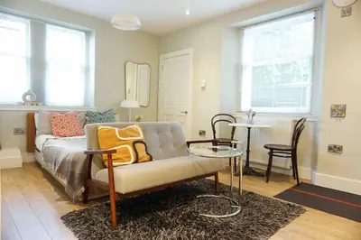 a living room with a couch and a table at Fully licensed studio in peaceful neighbourhood in Edinburgh