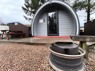 a circular house with a barrel in front of it at Barrhill Holiday Park - Glamping in South West Scotland - Duisk in Girvan
