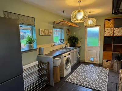 a kitchen with a washing machine and a sink at Borders Escape with Hot Tub in West Linton