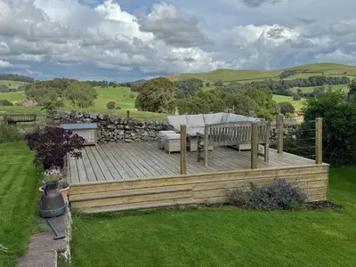 a wooden deck in the middle of a yard at Borders Escape with Hot Tub in West Linton
