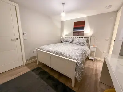 a bedroom with a bed in a white room at 2-Bed Flat in Glasgow East End in Glasgow