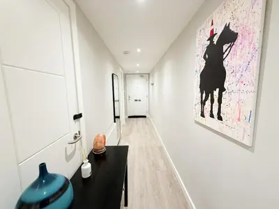 a hallway with a black table and a painting on the wall at 2-Bed Flat in Glasgow East End in Glasgow