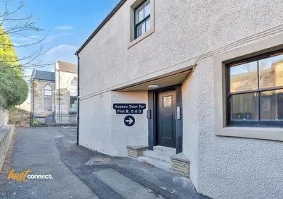 a building with a sign on the side of it at Central 2BR Flat at Wellwynd I Parking Included in Airdrie