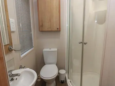a bathroom with a toilet and a sink and a shower at Serenity Lodge in Wemyss Bay