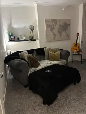 a living room with a couch and a guitar at 2 bedroom fully furnished apartment in Springburn