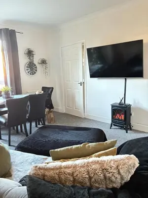 a living room with a fireplace and a flat screen tv at 2 bedroom fully furnished apartment in Springburn