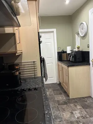 a kitchen with a stove and a counter top at 2 bedroom fully furnished apartment in Springburn
