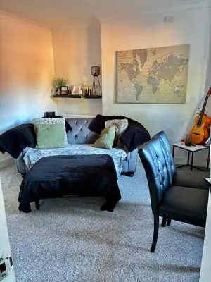 a living room with a couch and a chair at 2 bedroom fully furnished apartment in Springburn