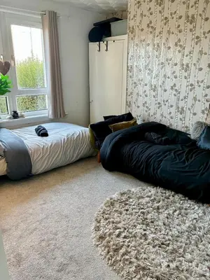 a bedroom with two beds and a rug at 2 bedroom fully furnished apartment in Springburn