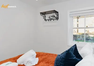 a bedroom with a bed with a light and a window at Comfy 1 Bed Airdrie Flat w Private Parking in Airdrie