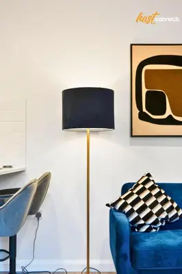 a living room with a blue chair and a lamp at Comfy 1 Bed Airdrie Flat w Private Parking in Airdrie