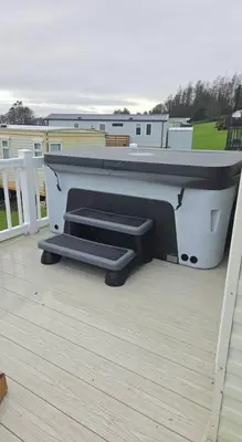 a bench sitting on a deck on a house at Noah's Luxe Retreats in Newton Stewart