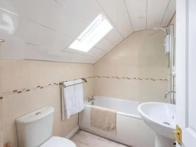 a bathroom with a toilet and a tub and a sink at Meadow Hill Cottage with Private Garden, Crieff in Crieff