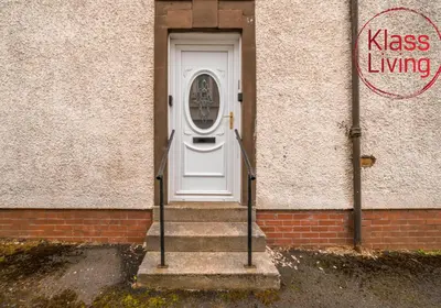 a white door on a brick building with stairs at Mc Culloch Apartment by Klass Living Viewpark in Uddingston