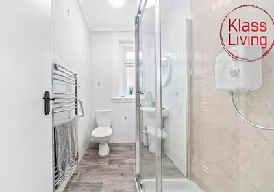 a bathroom with a shower with a toilet and a sink at Mc Culloch Apartment by Klass Living Viewpark in Uddingston