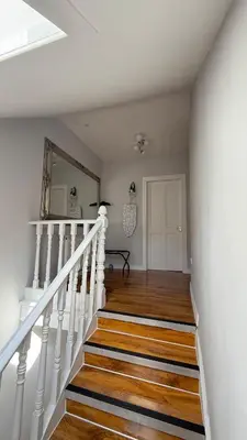 a white staircase with wooden floors and a mirror at Welcome to your perfect getaway in Glasgow