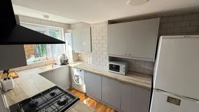 a kitchen with white cabinets and a white refrigerator at Welcome to your perfect getaway in Glasgow