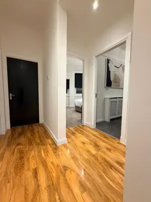 an empty living room with wood floors and a bedroom at The perfect place we call home 2 in Dumbarton