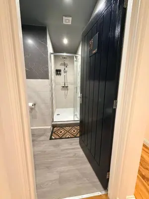 a bathroom with a shower and a black door at The perfect place we call home 2 in Dumbarton