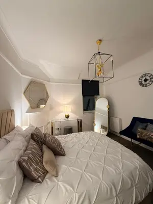 a bedroom with a large white bed with pillows on it at The perfect place we call home 2 in Dumbarton