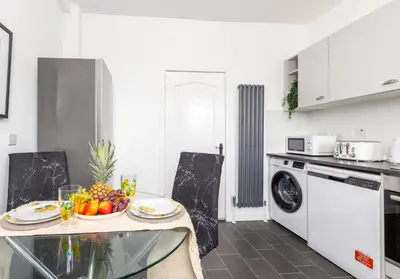 a kitchen with a table with a bowl of fruit on it at Broomfield No 31 by Klass Living Airdrie in Airdrie