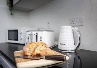 a loaf of bread on a cutting board with a knife at Broomfield No 31 by Klass Living Airdrie in Airdrie