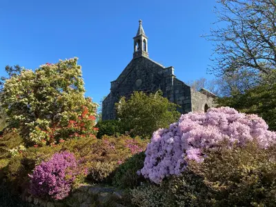 an old church with flowers in front of it at Lochview Flat in Onich
