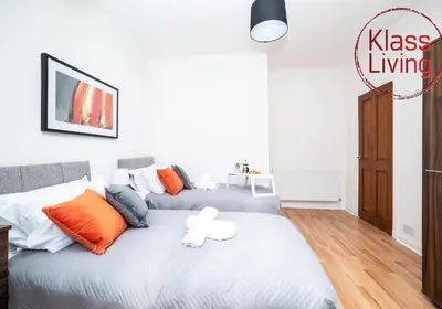 a bedroom with a large bed with orange and white pillows at Cosy Apartment by Klass Living Bellshill in Bellshill