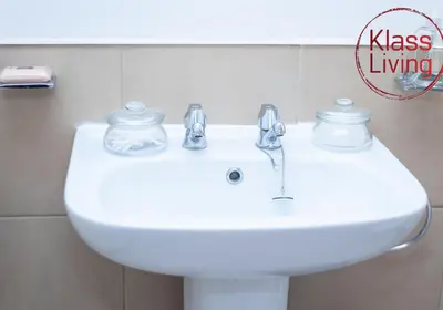 a white bathroom sink with two glass jars on it at Cosy Apartment by Klass Living Bellshill in Bellshill