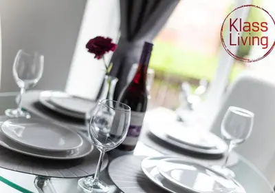 a table with glasses and plates and a bottle of wine at Cosy Apartment by Klass Living Bellshill in Bellshill