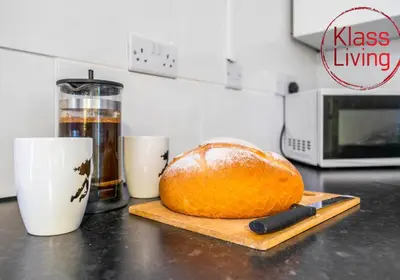 a loaf of bread on a cutting board on a kitchen counter at Elmbank Apartment by Klass Living Bellshill in Bellshill