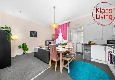 a kitchen and living room with a table and a couch at Elmbank Apartment by Klass Living Bellshill in Bellshill