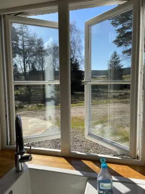 a kitchen window with a view of a yard at Keeper's Cottage at Slogarie Estate in Castle Douglas