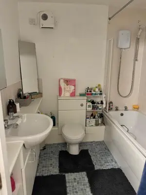 a bathroom with a sink and a toilet and a tub at Skyline Serenity Cosy Home in Glasgow