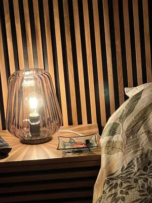 a lamp sitting on a table next to a bed at Luxury New York Style Loft Apartment Homestay in Edinburgh