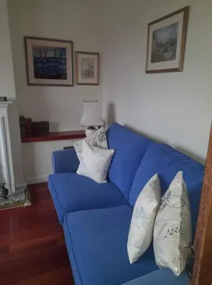 a blue couch with pillows on it in a living room at Celia's house in Stirling
