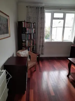 a living room with a book shelf and a window at Celia's house in Stirling