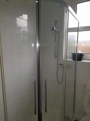 a shower with a glass door next to a toilet at Celia's house in Stirling