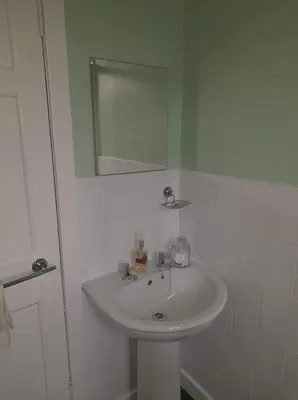 a bathroom with a white sink and a mirror at Celia's house in Stirling