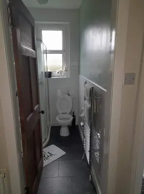 a small bathroom with a toilet and a window at Celia's house in Stirling