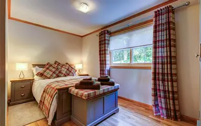 a bedroom with a bed next to a window at Scone Cottage - Luxury retreat, outstanding views in Craobh Haven