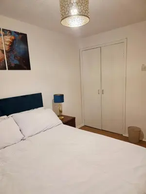 a bedroom with a white bed and a closet at Cozy 2Bed Flat in Glasgow City Center in Glasgow