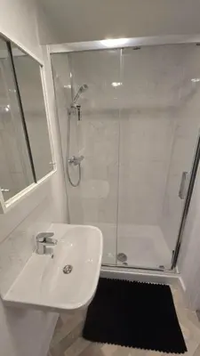 a white bathroom with a shower and a sink at 3,Lime Tree Ave in Moffat
