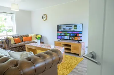 a living room with a couch and a flat screen tv at Stylish Stirling home with stunning views in Stirling