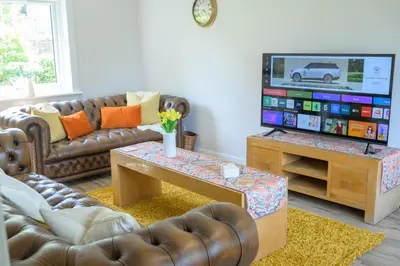 a living room with a couch and a tv at Stylish Stirling home with stunning views in Stirling
