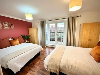 a bedroom with two beds and a large window at 3-Bedroom house near Manchester City Centre in Moffat