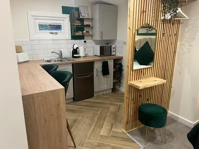 a kitchen with a sink and a counter with a mirror at The Wee Bank Hut in Oban